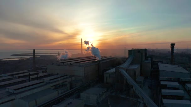 La zona industrial con humo blanco se vierte desde la tubería de la fábrica en contraste con el sol. Contaminación del medio ambiente: una tubería con humo. Vista aérea — Vídeo de stock