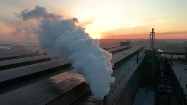 Strefy przemysłowej z rur gęsty biały dym wylewa się z rury fabryki w przeciwieństwie do słońca. Zanieczyszczenie środowiska: Rura dymu. Widok z lotu ptaka — Wideo stockowe