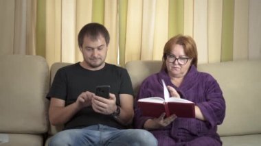 Cep telefonu ve bir yaşlı kadın bir kitap okuma kullanan genç adam