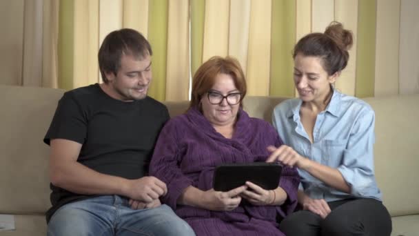 Soins aux jeunes travailleurs de soutien à domicile montrant aux femmes âgées comment utiliser une tablette d'ordinateur . — Video