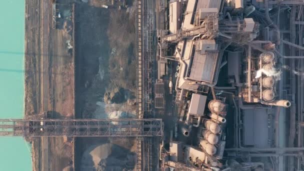 Aerial view over industrialized city with air atmosphere and river water pollution from metallurgical plant near sea. Dirty smoke and smog from pipes of steel factory and blast furnaces. Ecological — Stock Video