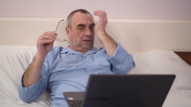 Üzgün adam kullanarak dizüstü yatakta ile tepki