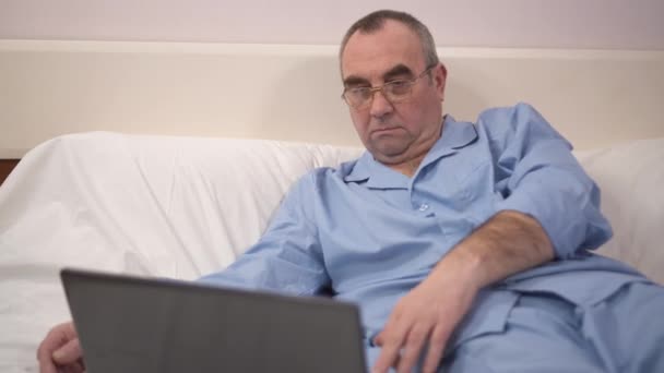 Reactie van succes door de gelukkige Man met Laptop in Bed — Stockvideo