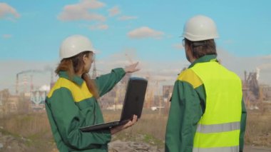 Tartışırken, endüstriyel sahne arka planda ekip olarak işçiler üretim tesisleri