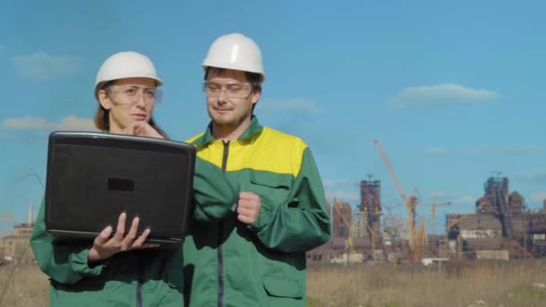 Workers in production plant as team discussing, industrial scene in background — Stock Video