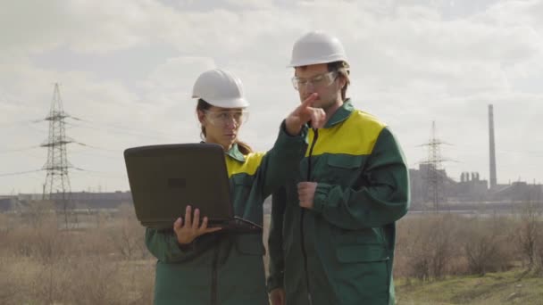 Werknemers in de productie van planten als team bespreken, industriële scène in achtergrond — Stockvideo