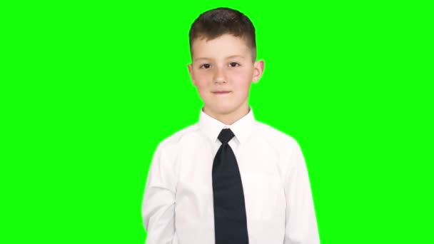 男孩站在演播室里, 对着镜头微笑, 竖起大拇指。在绿色屏幕上拍摄. — 图库视频影像