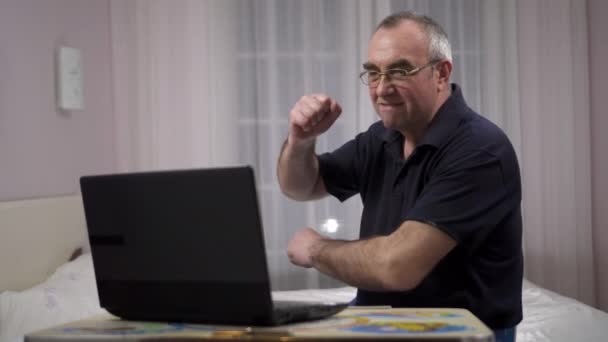 Idosos de cabelos grisalhos usando laptop, assistindo futebol em um laptop e fica chateado — Vídeo de Stock