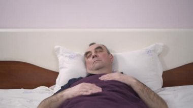 Yaşlı bir adam yatağında uyuyor, bir rüya, korku, anksiyete uyanış yatıyor
