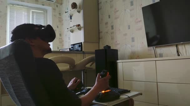Symulacja komputerowa. Wesoły młody gracz w goglach wirtualnej rzeczywistości wyraża emocje podczas korzystania z gry wideo — Wideo stockowe