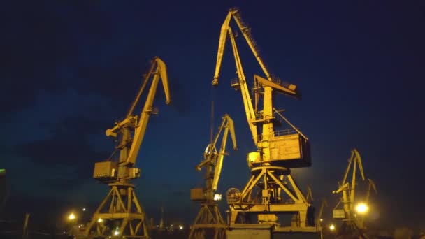 Grúas portuarias sobre la puesta del sol. 4K — Vídeo de stock