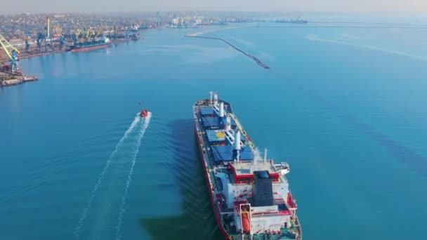 Luchtfoto. Groot vrachtschip betreedt de havenstad met havenkranen. — Stockvideo