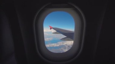 Güzel bir mavi gökyüzü ile pencereden uçak güzel bulut ve kanat. 4k