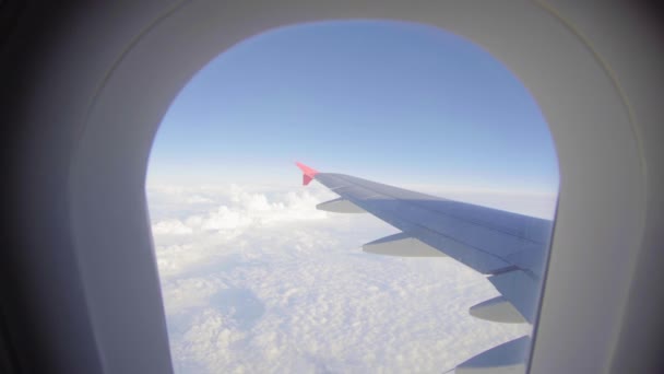 Uçak uçuşu. Bulutların üzerinde uçan bir uçağın kanadı. Uçağın penceresinden bak. Uçak. Hava yoluyla seyahat etmek. 4K UHD video — Stok video