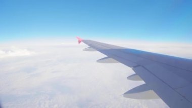 Uçak uçuşu. Bulutların üzerinde uçan bir uçağın kanadı. Uçağın penceresinden bak. Uçak. Hava yoluyla seyahat etmek. 4K UHD video