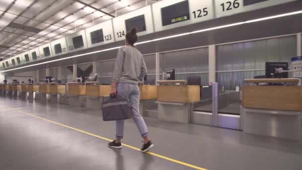 A menina vai ao terminal para registro com uma bolsa . — Vídeo de Stock