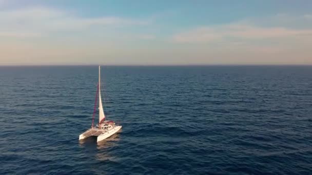 Vista aérea. Catamarã vai pelo mar, câmera se aproximar e voar sobre o navio, no pôr do sol, bela vista — Vídeo de Stock