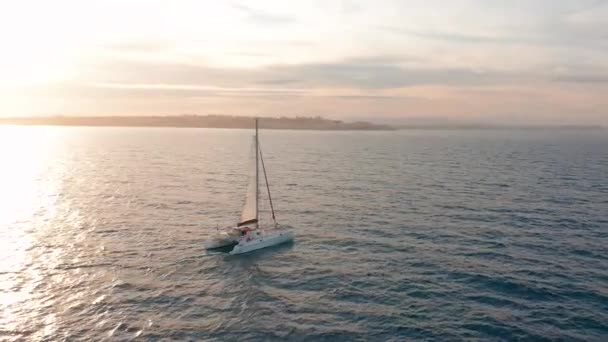 Vista aérea. Catamarã vai pelo mar, câmera se aproximar e voar sobre o navio, no pôr do sol, bela vista — Vídeo de Stock