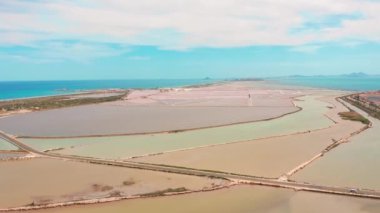 Kıyı tuz bataklıkları ile çok renkli tuz gölleri, havadan görünümü, drone ile video çekim. Pembe tuz gölleri ve turkuaz deniz, hava video.