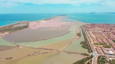 Kıyı tuz bataklıkları ile çok renkli tuz gölleri, havadan görünümü, drone ile video çekim. Pembe tuz gölleri ve turkuaz deniz, hava video.