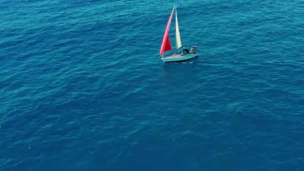 Luchtfoto. Zeiljacht met rood zeil in de open zee. — Stockvideo