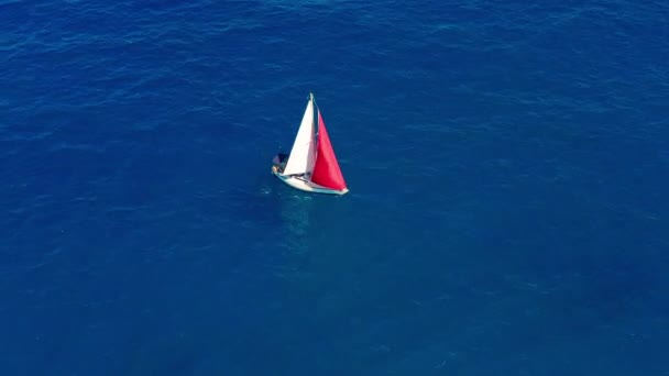 Luchtfoto. Zeiljacht met rood zeil in de open zee. — Stockvideo