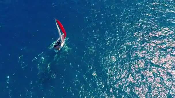 Vista aérea. Hermoso velero en el fondo azul océano en un día soleado brillante . — Vídeo de stock