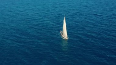 Havadan görünüm. Güneşli bir günde açık denizde yelken. Denizde yelkenli tekne.
