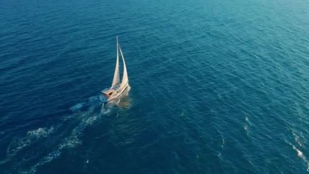 Okyanusta yelkenli. Sınırsız okyanusun ortasında beyaz yelkenli yat. Havadan görünüm. — Stok video