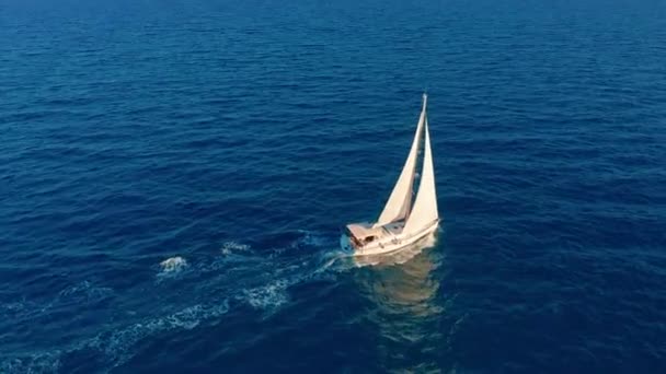 Segelboot im Ozean. weiße Segeljacht inmitten des grenzenlosen Ozeans. Luftbild. — Stockvideo