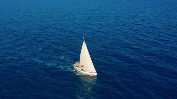 Segelbåt i havet. Vit Segelbåt mitt i det gränslösa havet. Utsikt från luften. — Stockvideo