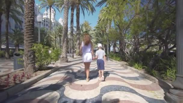 Mutlu bir aile dışarıda. anne ve oğlu deniz kenarında yürümek. — Stok video