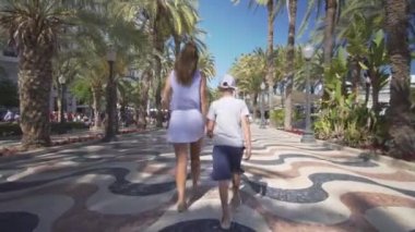 Mutlu bir aile dışarıda. anne ve oğlu deniz kenarında yürümek.