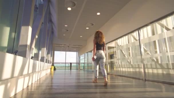 Young handsome woman going to boarding plane at the airport terminal. — Stock Video