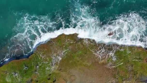 Flygvy. Vågor kraschar på klippor. — Stockvideo