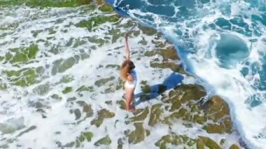Rocky Beach Cliff üzerinde duran Seksi Kız. Bir kadın mesafeye bakar..