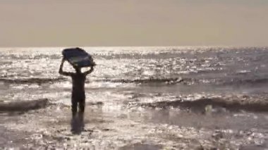 Küçük çocuk, denizde vücut biniş ile koşan.