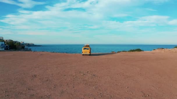 Kalifornien, Vereinigte Staaten, 20. Juli 2019: Luftaufnahme. Gelber VW-Bus auf einem Parkplatz auf einem Felsen in Meeresnähe. — Stockvideo