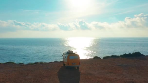 Californie, États-Unis, le 20 juillet 2019 : Vue aérienne. VW van bus jaune sur un parking sur un rocher près de la mer . — Video