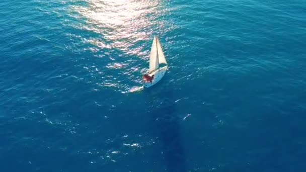 Légifelvétel. Vitorlás hajó nyílt tengeren napsütéses napon. — Stock videók