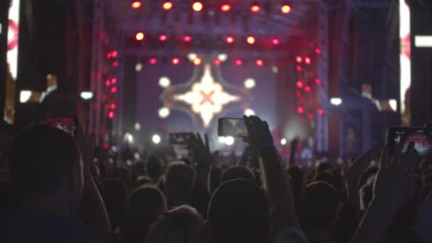 Éjszakai legendás koncert. Az emberek felvidítani mozog, és tapsolnak a kezüket egyszerre ellen strobing színpadi fények. — Stock videók