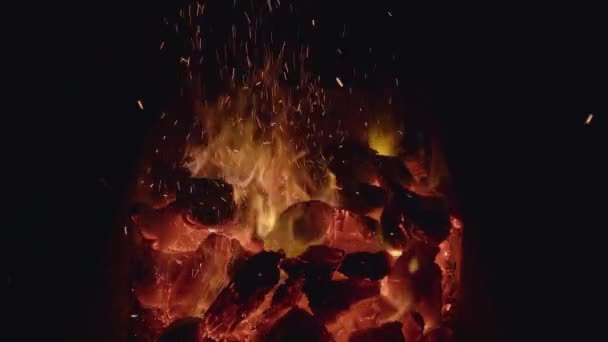 Primer plano de carbones negros ardiendo. Acción. Quemando pequeñas llamas sobre carbones para barbacoa en la naturaleza. Carbones calientes . — Vídeo de stock