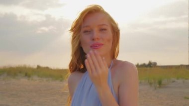 T-shirt gülümseyen zencefil kadın kameraya hava öpücük gönderir.