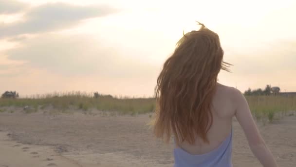 Портрет посмішки жінки, що обертається на пляжі під час заходу сонця . — стокове відео
