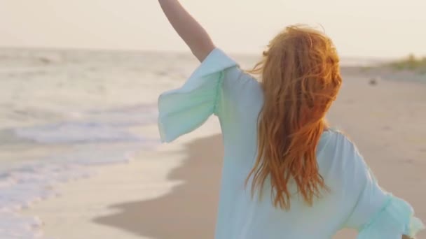 年轻的漂亮女人在沙海边缓慢地旋转。度假海滩. — 图库视频影像