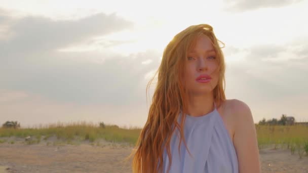 The Redheaded girl smiles at the camera at sunset. Close-up. — Stock Video