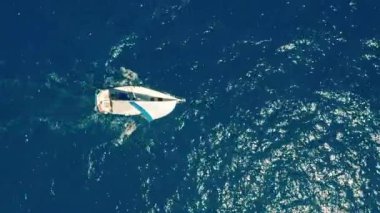 Okyanusta yelkenli. Sınırsız okyanusun ortasında beyaz yelkenli yat. Havadan görünüm.