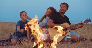 Akşam sahilde piknik sırasında yangın mutlu aile.