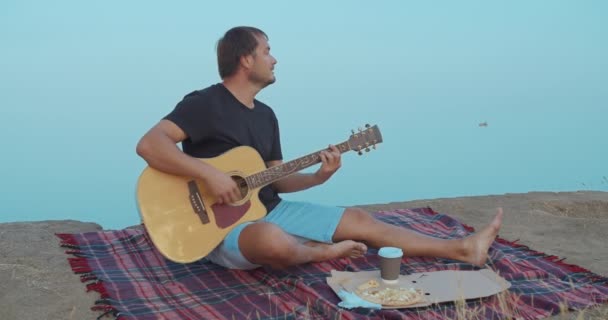 L'uomo che suona la chitarra e canta sulla spiaggia . — Video Stock