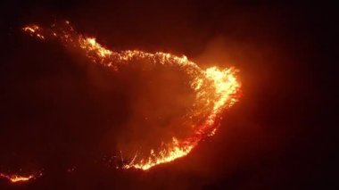 Havadan görünüm. Gece yangını. Tarlada kuru ot yakıyor. 4k.